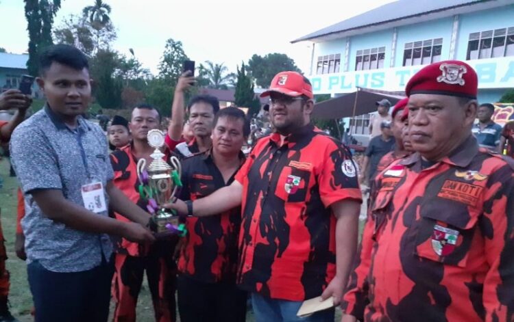 Elkananda Shah SE memberikan piala dan hadiah kepada tim manager 'Komando FC' yang meraih juara pertama. (ist/tsp)